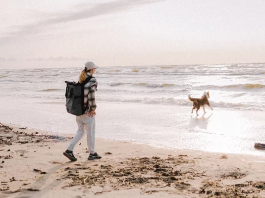 Fastenwoche mit dem Hund - Frau am Strand mit Hund
